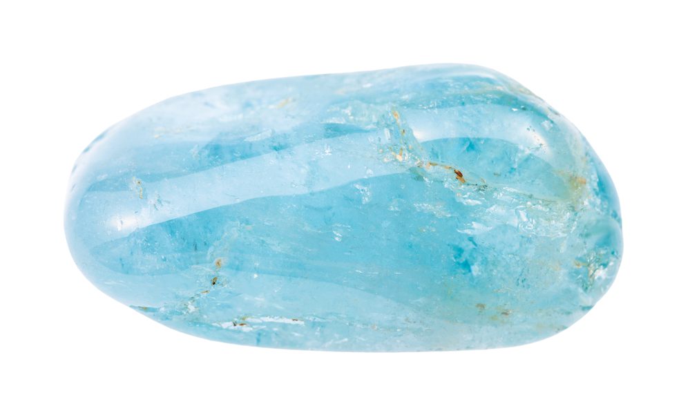 closeup of sample of natural mineral from geological collection - tumbled Aquamarine (blue Beryl) gem stone isolated on white background